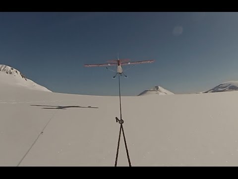 Aviat Husky tows skier up mountain in Alaska